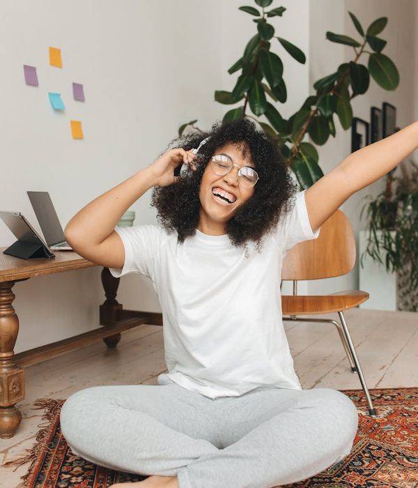 Woman with closed eyes smiling peacefully in a bright room.
